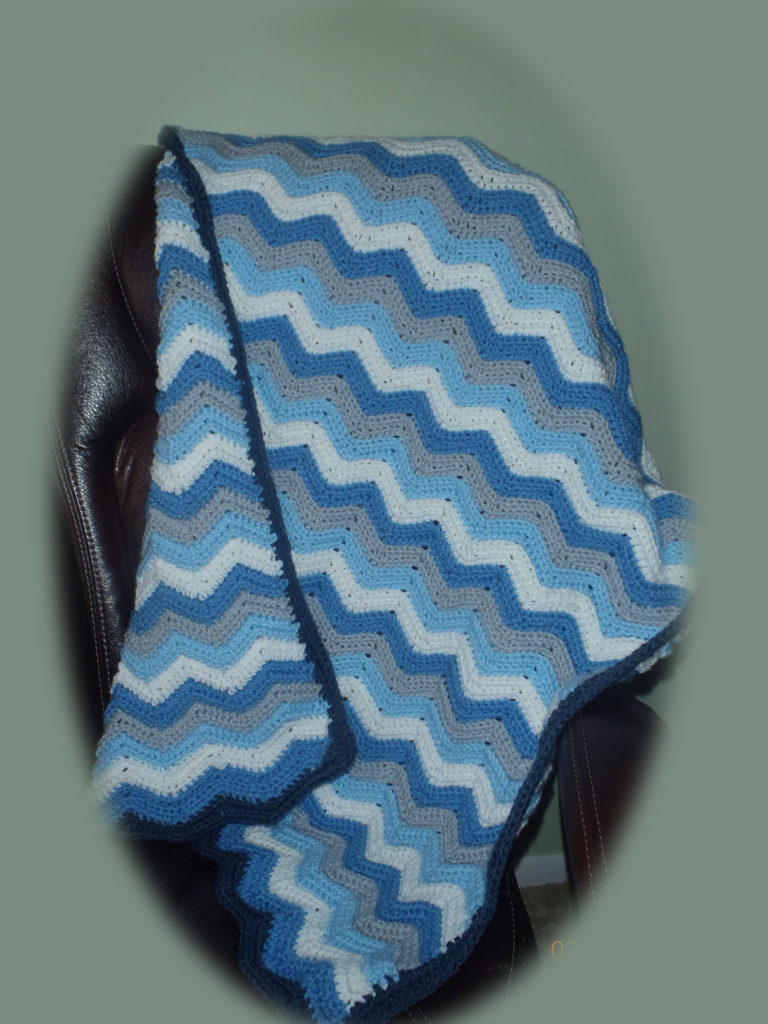 crocheted light blue, grey, white wave pattern baby throw