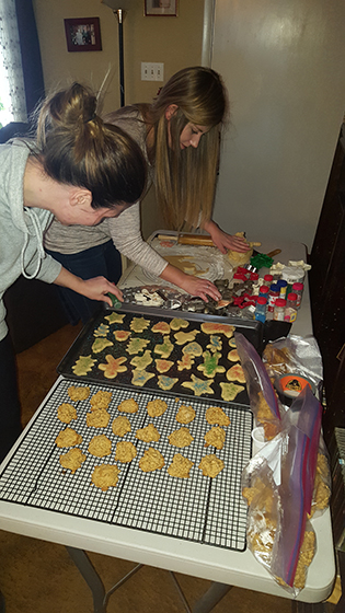 2 young woman decorating Christmas cookies