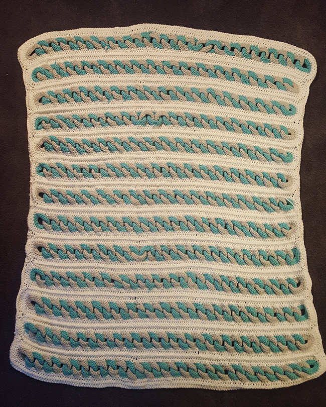 Braided strips blanket teal, white, and grey colors