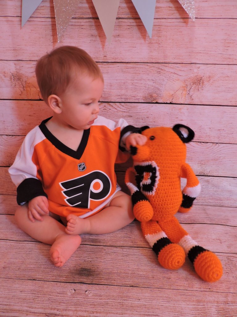 crocheted orange, white and black  doll with floppy legs and arms