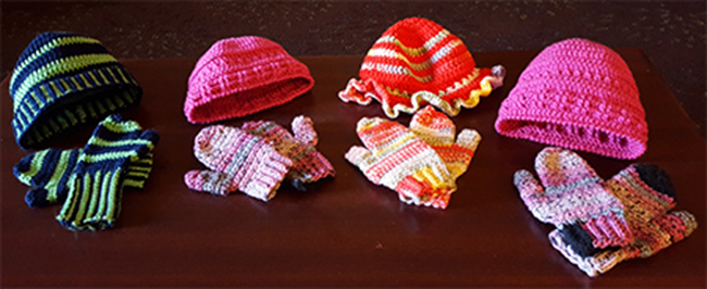 Four sets of crocheted hat and mitten sets. Multiple colors.