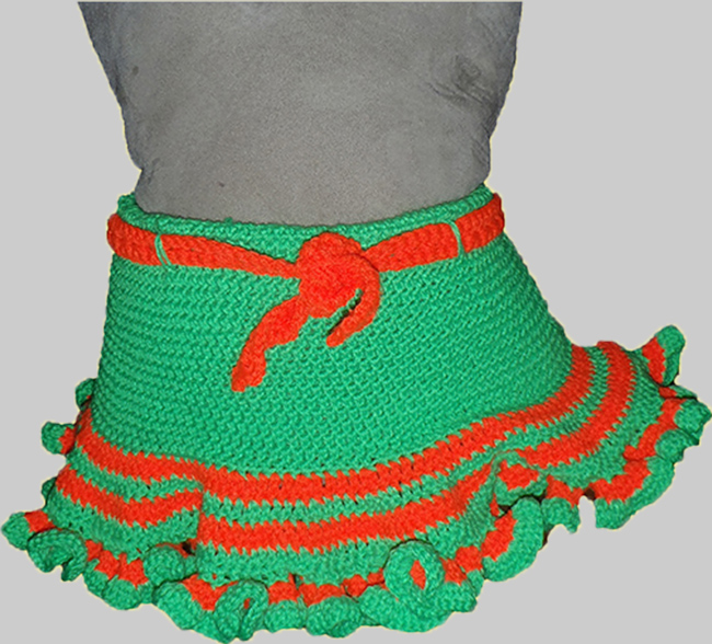 bright green crocheted skirt with bright orange and green stripes at the bottom and frill.  Adorned with a bright orange crocheted belt